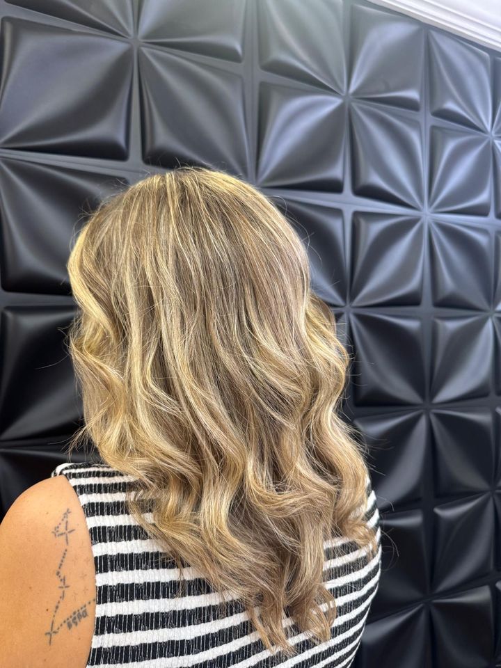 Golden blonde waves against the studio wall
